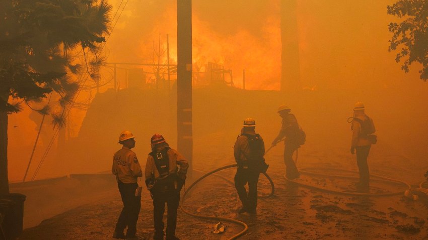 RUNNING SPRINGS, CA – SEPTEMBER 10, 2024:  Firefighters can do little to save an engulfed home as the Line fire burns into a tree lined neighborhood  on September 10,  2024 in Running Springs, California. (Gina Ferazzi / Los Angeles Times via Getty Images)