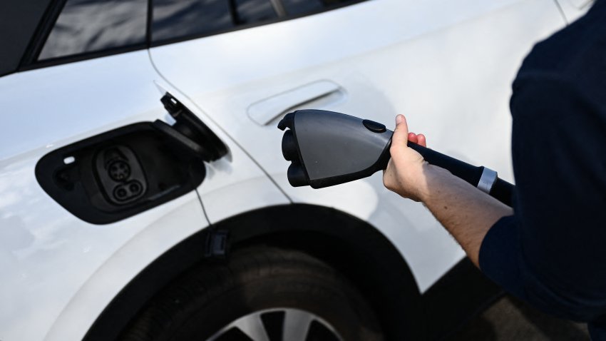 A driver uses a CCS DC fast charger from Electrify America to charge a Volkswagen ID.4 electric vehicle (EV) at a shopping mall parking lot in Torrance, California, on February 23, 2024. (Photo by Patrick T. Fallon / AFP) (Photo by PATRICK T. FALLON/AFP via Getty Images)