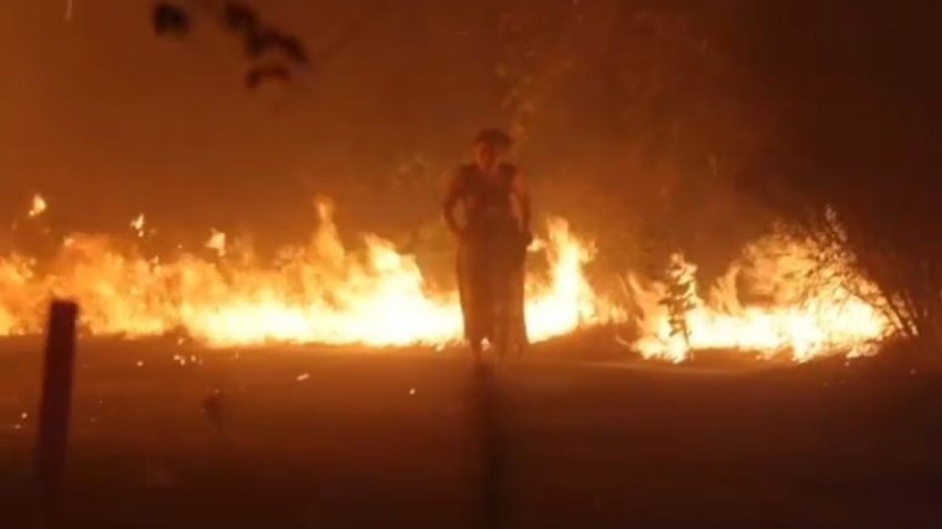 Video showed a firefighter rescue a woman surrounded by flames Sept. 10, 2024 during the Airport Fire in the Southern California mountains.